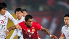 Guangzhou Evergrande midfielder Paulinho (middle) competes for the ball against three Urawa Red Diamonds players