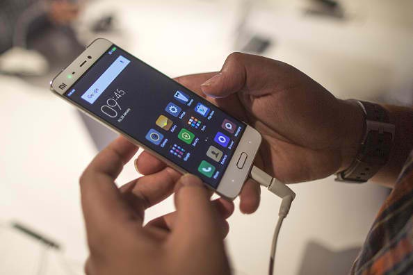 An attendee inspects a Xiaomi Corp. Mi 5 smartphone during a launch event in New Delhi, India, on Thursday, March 31, 2016. 