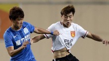 Hebei CFFC striker Dong Xuesheng (R) competes for the ball against Guangzhou R&F's Zhang Xianxiu