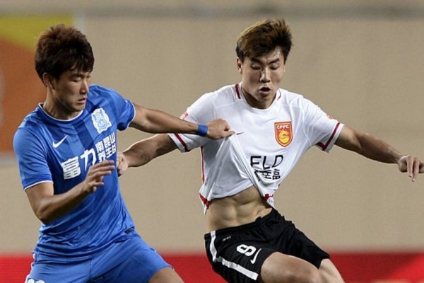 Hebei CFFC striker Dong Xuesheng (R) competes for the ball against Guangzhou R&F's Zhang Xianxiu