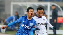 Guangzhou R&F midfielder Wang Jia'nan (L) goes against Tianjin Teda's Zhou Tong