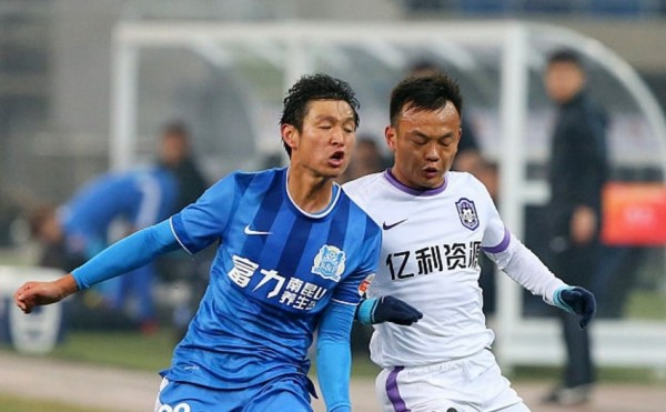 Guangzhou R&F midfielder Wang Jia'nan (L) goes against Tianjin Teda's Zhou Tong