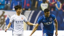 Yanbian Funde midfielder Yoon Bit-garam (L) competes against Shanghai Shenhua's Giovanni Moreno. 