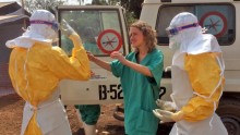 Healthcare workers react as they prepare isolation and treatment areas for their Ebola, hemorrhagic fever operations, in Gueckedou, Guinea, on Friday, March 28, 2014.  