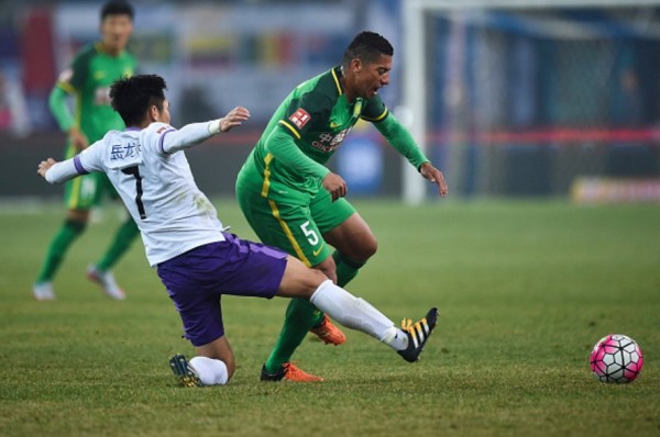 Beijing Guoan midfielder Ralf (R) competes for the ball against Tianjin Teda's Li Benjian