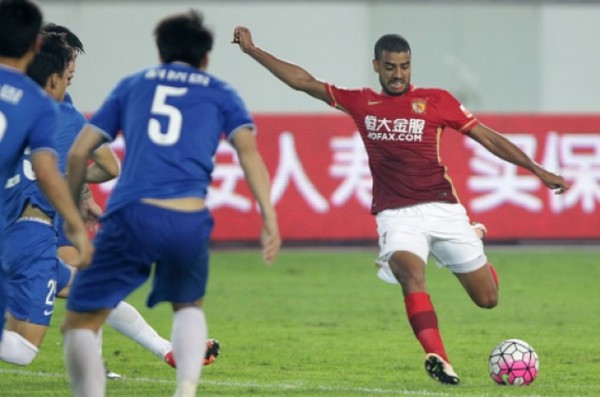 Guangzhou Evergrande winger Alan Carvalho (R) against Henan Jianye defenders