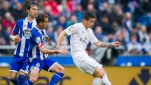Real Madrid midfielder James Rodriguez (R) competes for the ball against two Deportivo La Coruna defenders
