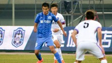 Guangzhou R&F striker Xiao Zhi drives against Tianjin Teda defenders