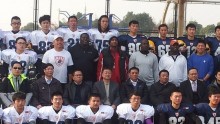 Ricky Williams (orange Texas hat) poses with Chinese players for a team photo.