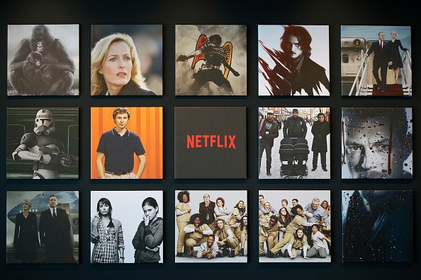 Promotional images of Netflix Inc. programs are displayed on a wall 