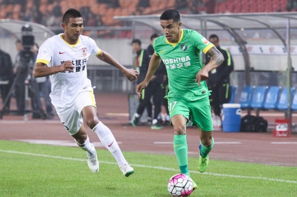 Hangzhou Greentown forward Tim Cahill (R) dribbles past Changchun Yatai's Anzur Ismailov