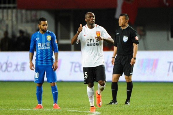 Hebei China Fortune midfielder Stéphane Mbia (middle) reacts with Jiansu Suning's Alex Teixeira during a match