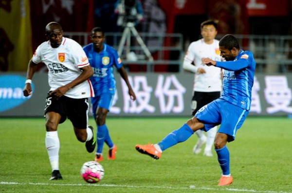 Hebei China Fortune midfielder Stéphane M'Bia (L) runs to the ball as Jiangsu Suning's Jorge Sammir shoots it