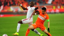 Liaoning Whowin striker James Chamanga (L) competes for the ball against Shandong Luneng's Hao Junmin