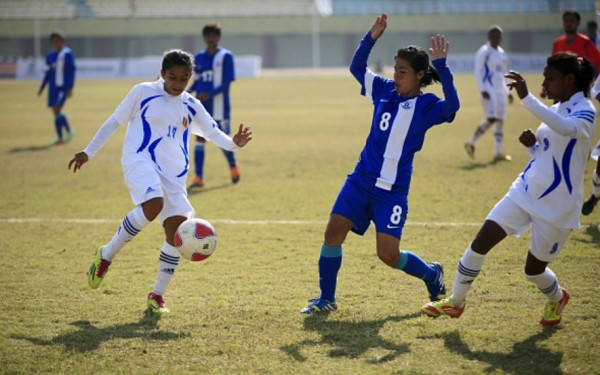 Indian women's national team midfielder Mandakini Devi (#8) competes for the ball with two Sri Lankan defenders