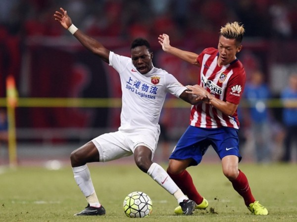 Shanghai SIPG forward Jean Evrard Kouassi competes for the ball against Atletico Madrid's Xu Xin during a friendly match
