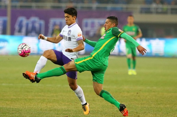 Beijing Guoan defensive midfielder Ralf (R) competes for the ball against Tianjin Teda's Fredy Montero
