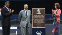 Joe Torre (middle) and his wife (right) in a ceremony to retire his number