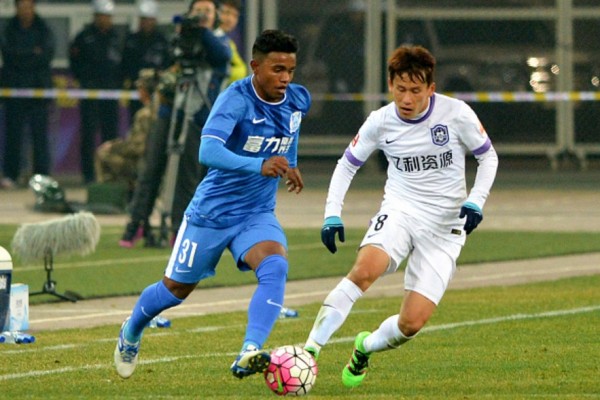 Guangzhou R&F winger Renatinho (L) competes for the ball against Tianjin Teda's Hu Rentian