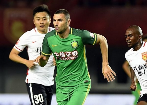 Beijing Guoan striker Burak Yilmaz (middle) against two Hebei China Fortune defenders