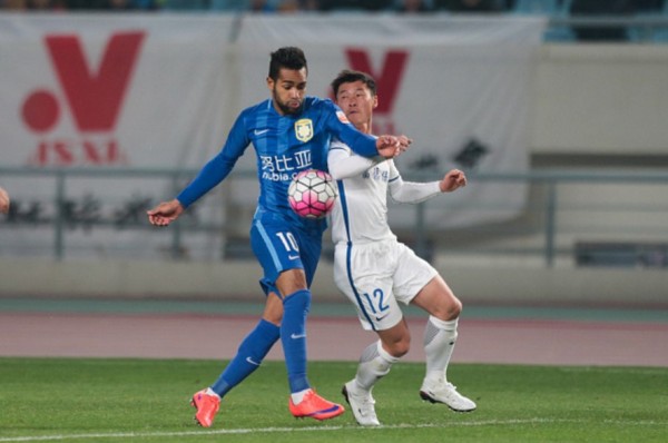 Jiangsu Suning winger Alex Teixeira (L) competes for the ball against Yanbian Funde defender Jiang Hongquan