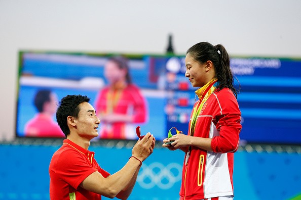  Chinese diver Qin Kai proposes to silver medalist He Zi of China on the podium during the medal ceremony for the Women's Diving 3m Springboard Final on Day 9 of the Rio 2016 Olympic Games at Maria Lenk Aquatics Centre on August 14, 2016 in Rio de Janeiro