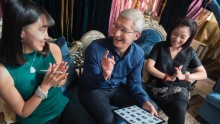Tim Cook holds an iPad showing pictures of Guo Pei's designs in Beijing, August 15. 2016. 