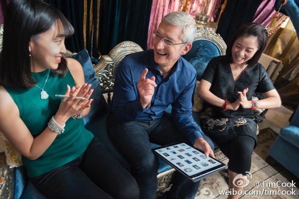 Tim Cook holds an iPad showing pictures of Guo Pei's designs in Beijing, August 15. 2016. 