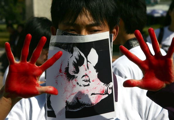 A student acts as a slaughtered pig during a performance art activity to promote animal protection in Changchun of Jilin Province, northeast China.