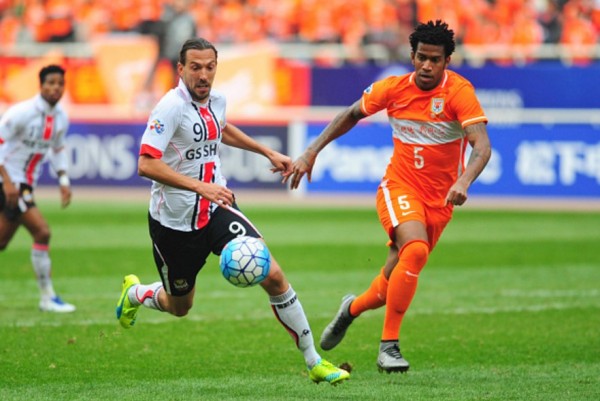 FC Seoul striker Dejan Damjanovic competes for the ball against Shandong Luneng defender Gil