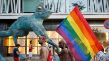 Gay activists demonstrate in the streets while holding the gay pride flag