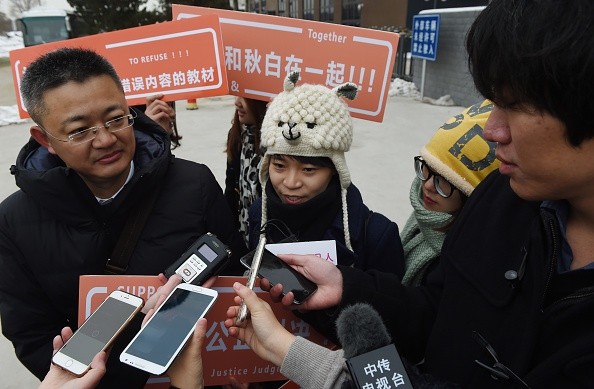 Qiu Bai, speaks to the media with her lawyer Wang Zhenyu (L) before entering the Beijing No.1 Intermediate People's Court in Beijing on November 24, 2015. Qiu Bai took the government to court over textbooks describing homosexuality as a 'psychological dis
