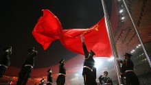 Soldiers salute in respect to China's flag as it is being raised.