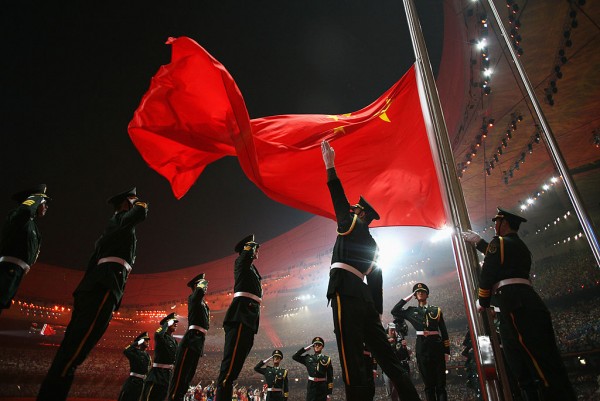 Soldiers salute in respect to China's flag as it is being raised.