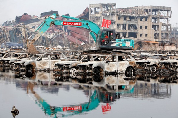  Rescuers and machines clean up burnt vehicles at the site of Tianjin warehouse explosion on August 20, 2015 in Tianjin, China
