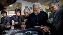 Elderly Chinese residents serve themselves lunch in the dining hall of the Ji Xiang Temple and nursing home on March 17, 2016 in Sha County, Fujian province, China.