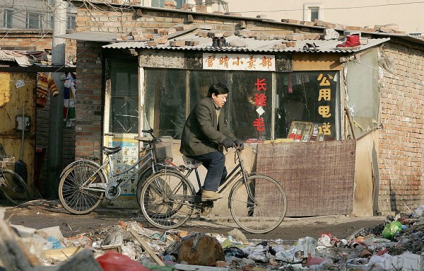  A cyclist rides past a public telephone booth in a poor slum area on January 2, 2005 in Beijing, China. 