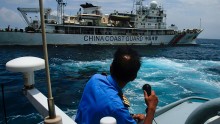 A member of the Malaysian Navy makes a call as their ship approaches a ship belonging to the Chinese Coast Guard during an exchange of communication in the South China Sea on March 15, 2014 in Kuantan, Malaysia. 