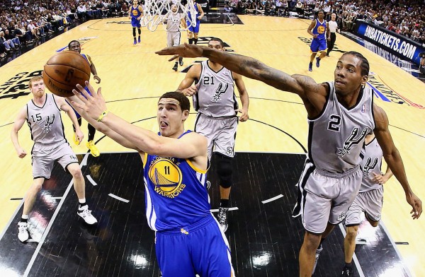 Golden State Warriors shooting guard Klay Thompson (L) evades the defense of San Antonio Spurs' Kawhi Leonard.