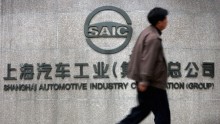 A Chinese man walks past the office building of Shanghai Automotive Industry Corp. (SAIC) on April 12, 2005 in Shanghai, China. 