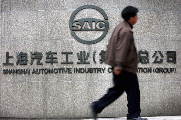 A Chinese man walks past the office building of Shanghai Automotive Industry Corp. (SAIC) on April 12, 2005 in Shanghai, China. 