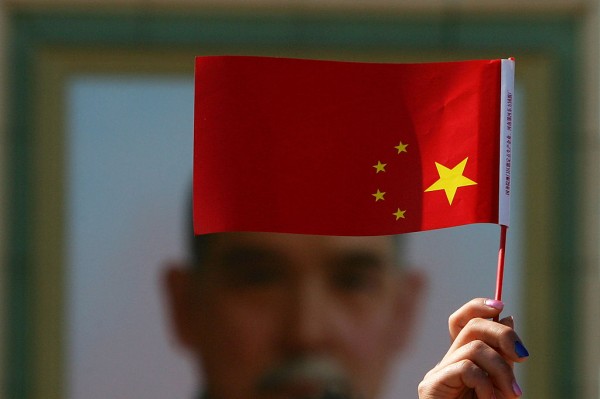 A woman holds a Chinese flag during demonstrations against corruption in China