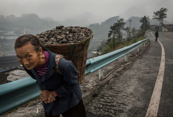 A Chinese woman carries coal in the hills above the Chishui River